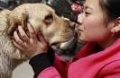 kisses her guide dog Yile,
