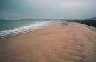 Sandstorm at The Burrows. The wind is producing low 'dunes' on the beach, - via Daymix