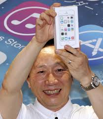 NTT docomo President Kaoru Kato lifts a newly released Apple&#39;s iPhone as he poses for photographers during a ceremony to mark the first day sales of the ... - B_Id_421722_Kaoru_Kato_