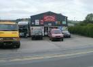 wall are 'Car Care Centre' 'Towbars fitted here' and 'Air Con regassed'. - via Daymix