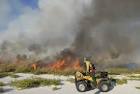 Fireman monitors controlled fire driving on a motor vehicle public domain - via Daymix