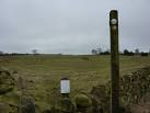 Footpath sign and small footbridge. A notice at the entrance to the field - via Daymix