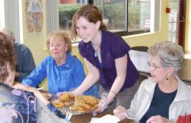 Leslie Pyne \u0026#39;12 offers a table of senior citizens cookes and muffins. Leslie Pyne \u0026#39;12 offers cookes and muffins to a table of senior citizens. - seniordesserts3