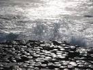 The wet basalt clearly shows the crystalline shapes of the columns, - via Daymix