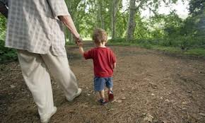 Grandparent and child walking in the woods