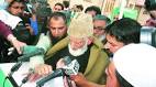 Masarat Alam by side, Pakistan flags in crowd, Syed Geelani steps.