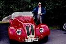 Laxey Wheel - Custom red sports car in parking area - via Daymix