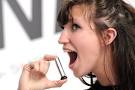 A woman tastes a mini spray of