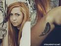 Brandi Cyrus' Tattoos & Meanings | Steal Her Style - brandi-cyrus-cross-feather-tattoo