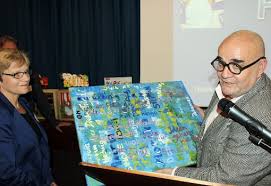 Rektorin Hedwig König und Felix Starosta mit einem Gemälde, das alle 32 Realschul-Kollegen als Abschiedsgeschenk geschaffen und signiert haben.