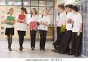 Teen Boys Flirting With Teen Girl In School Corridor Stock Photo