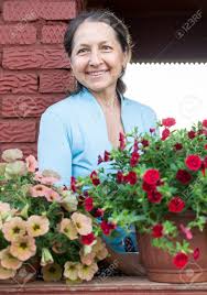 熟女主婦家庭内画像|主婦が自宅のソファに座り、笑顔で携帯電話で話す。の写真素材・画像素材 Image 196773028