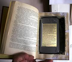 Image showing an electronic reading device such as a Kindle inside of a print book. 